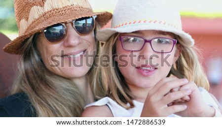 Mother and little girl together mom kissing daughter casual family moment