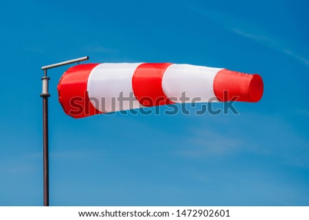 Windsock indicator of wind on runway airport. Royalty-Free Stock Photo #1472902601