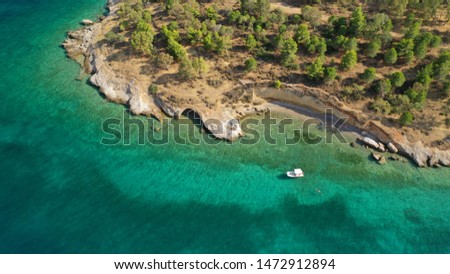 Aerial drone bird's eye view photo of small boats docked in tropical caribbean paradise bay with white rock caves and turquoise clear sea