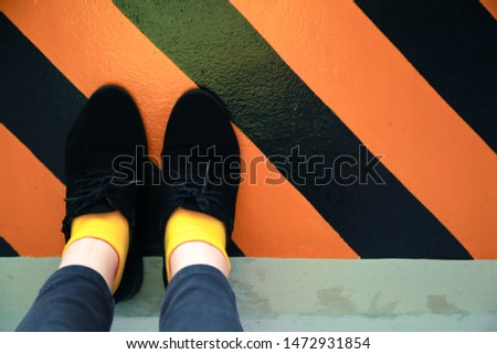 The girl wearing black trousers  Yellow sock And black shoes Walk in the parking area With lifestyle and vintage background images.