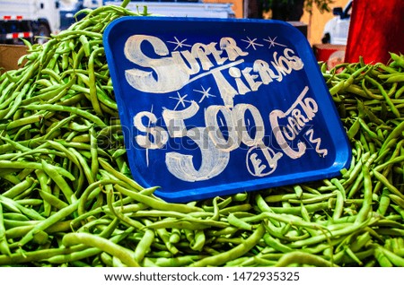 Vegetables displayed in a farmers market. Text on the picture: Super tender, 500 pesos a quarter kilo.