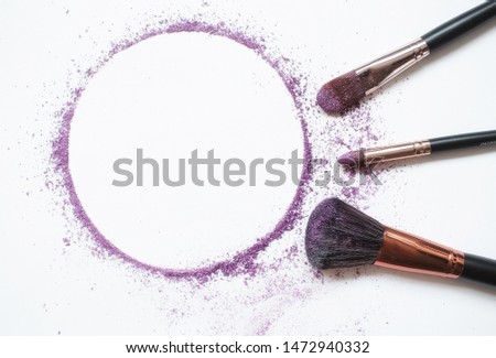 A makeup brush on a white background, with traces of 
eye shadow on it forming a frame. A horizontal template for a makeup school business card or flyer design, with plenty of copyspace