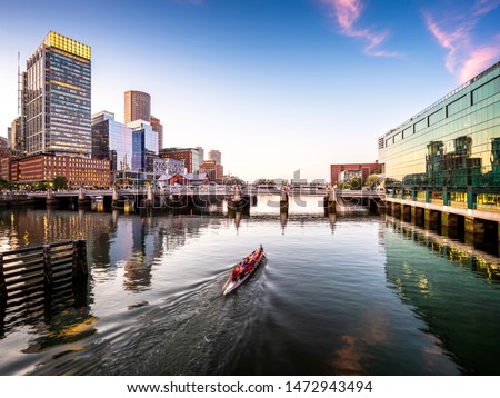 Panoramic view of the city of Boston in Massachusetts, USA at night showcasing its mix of contemporary and historic architecture by Seaport Boulevard. Royalty-Free Stock Photo #1472943494