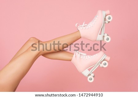 Beautiful shapely legs isolated on the pink background.