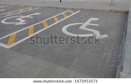 specialized handicapped parking lot in front of mosque with handicapped symbol with white paint and yellow paints applied on tarmac road or asphalt road