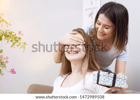 girlfriends giving gift box each other 