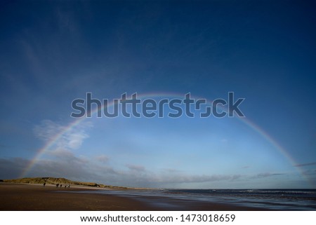 Druridge Bay in Northumberland is seven miles of beautiful beach between Cresswell and Amble. This image was taken on a bright  after rain with a beautiful rainbow brightening the sky.