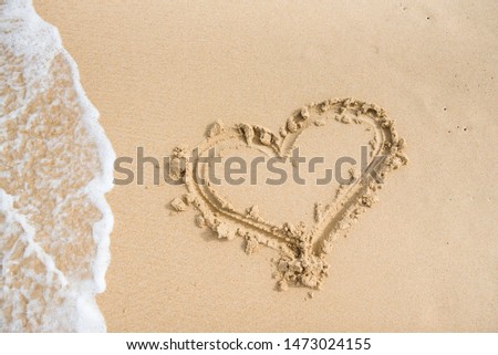 painted heart on the sand washes away the wave, background