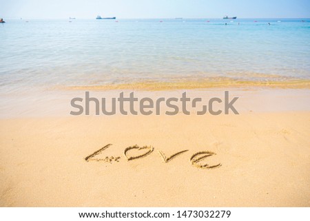 Love write on sand at beach
