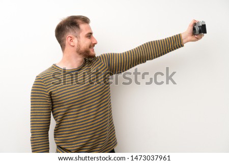Handsome man over isolated white wall making a selfie