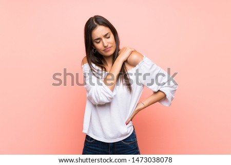 Young woman over isolated pink background suffering from pain in shoulder for having made an effort