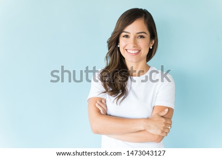 Charming Caucasian woman with arms crossed smiling against colored background