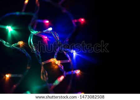 Christmas lights, Christmas background with  glowing Garlands on black background, space for Text