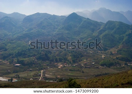 Rice fields terraces with beautiful mountains in the background. Village at the bottom of the valley. Shot in Sapa, Vietnam. 