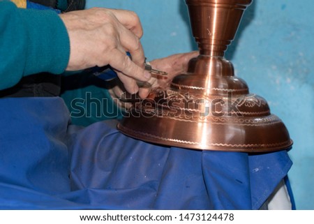 Coppersmith working at work. Working with engraving pen during hand stamping or engraving decoration pattern on metal plate ,Suleymaniye,Istanbul  Royalty-Free Stock Photo #1473124478