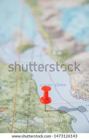 Part of the world topo map as ultimate item for successful travel and red push pin as location marker