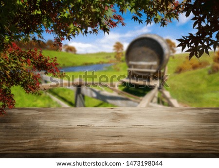 Brown wood table in autumn vineyard landscape with empty copy space on the table for product display mockup. Winery and wine tasting concept.