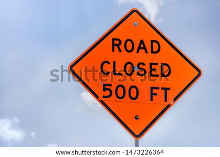 Vibrant orange Road Closed at 500 ft sign against the bright blue sky in Madison, Wisconsin.