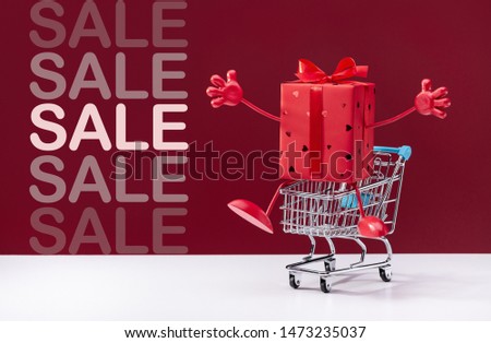 Festive red box with legs and hands in  shopping cart. Discounts, sale.
