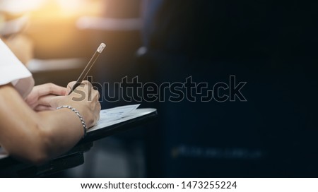 soft focus.high school student study.hands holding pencil writing paper answer sheet.sitting lecture chair taking final exam attending in examination classroom.concept scholarship for education abroad Royalty-Free Stock Photo #1473255224