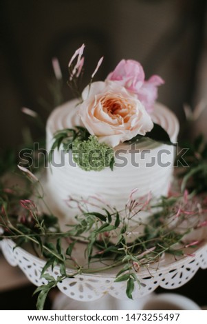 Small White Wedding Cake with flowers on top, peonies on wedding cake at reception 