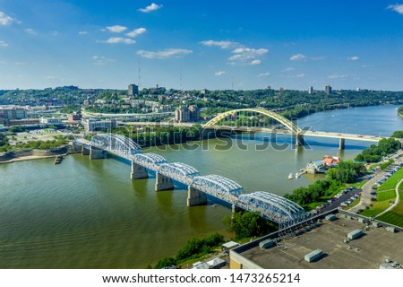 The yellow Daniel Carter Beard Bridge and the Purple People Bridge in Cincinnati Ohio over the Ohio river with blue sky