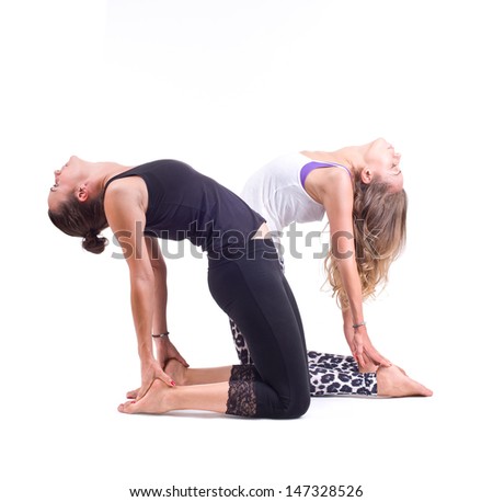 Practicing Yoga exercises in group. Two girls doing  Yoga exercises in studio on white background.  Pose name: Camel Pose - Ustrasana 