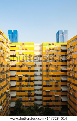 A yellow building with a lot of windows, blue sky