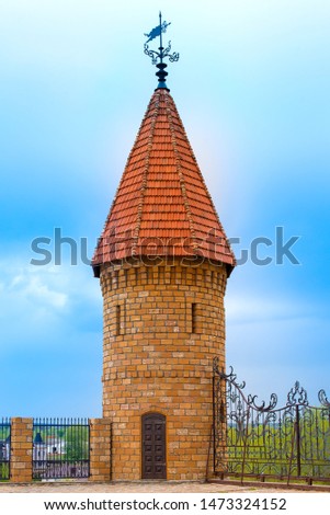 Tower with red pointed roof and weather vane