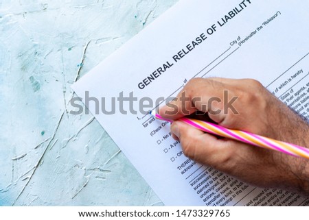 Person filling General Release of Liability form paper on bright background Royalty-Free Stock Photo #1473329765