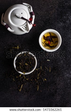 Floral tea concept with tea pot and cups on stone background with copy space