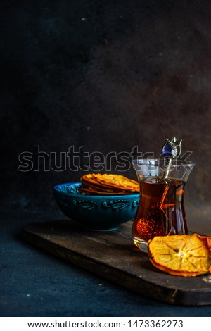 Turkish tea concept with dried persimmons on dark background with copy space