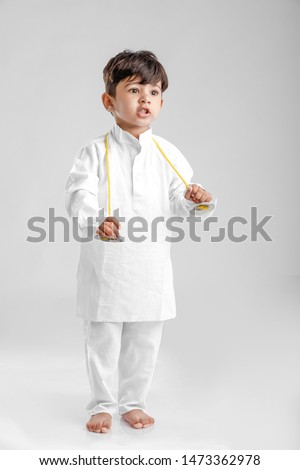 Indian Little Boy in Traditional Dress and learning with Musical instrument 