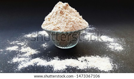 wheat flour in bowl isolated on black background