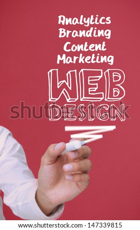 Businessman holding a marker and writing web design on red background