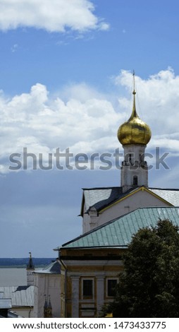 View on roofs and golden dome of church by lake and horizon under bright sky