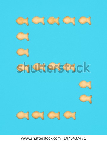 Numeral 5 Five from cookies in the shape of fish on a blue background