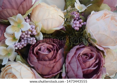 beige and purple artificial roses or peonies flowers for wedding decoration, decorative bouquet on a white curtain