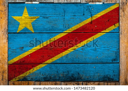 National flag of Democratic Republic of the Congo on a wooden wall background.The concept of national pride and symbol of the country.Flag painted on a wooden fence with metal nails.