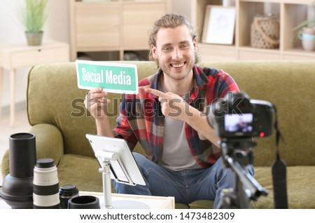 Male photographer recording video for his blog at home