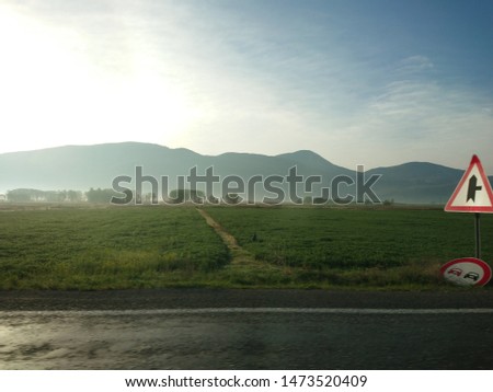 Beautiful harmony of mountains and meadow and red traffic sign