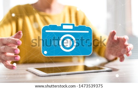Digital tablet with photography concept between hands of a woman in background