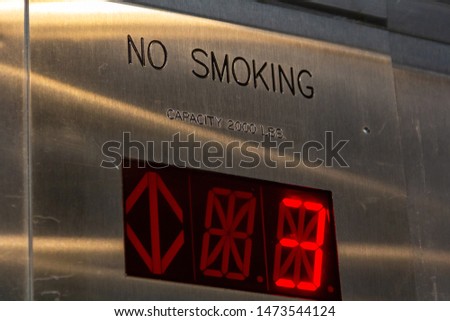 The display of the elevator monitor with the number 3 is red, close-up, the inscription do not smoke above the display, and the inscription weight restrictions.