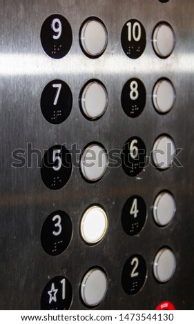 The elevator buttons in a natural setting, on a stainless metal panel, are a little dirty and scratched. Concept, technical structure of houses.