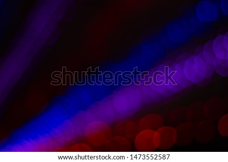 night unfocused pink blue and red bokeh ray of light illumination from some event decoration garland lamps in darkness 