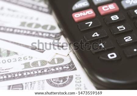 A few dollars and a calculator on the table, finance and savings.Business concept