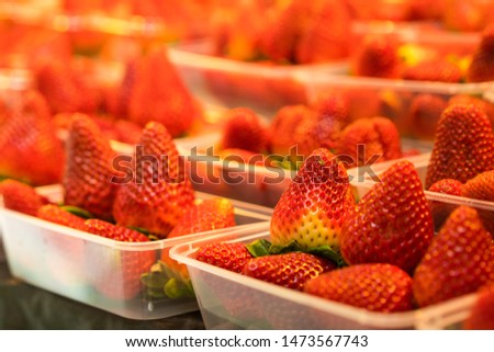 Fresh strawberries in baskets . Strawberries are sold in boxes ready for eating.