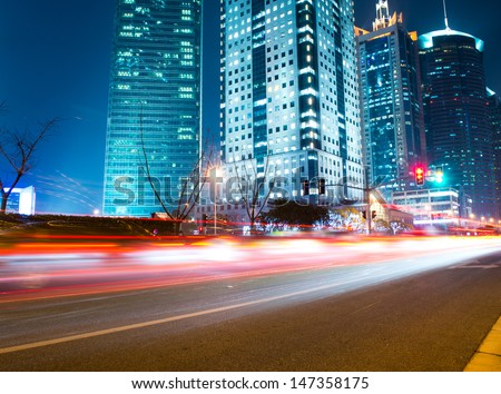 moving car with blur light through modern city at night.