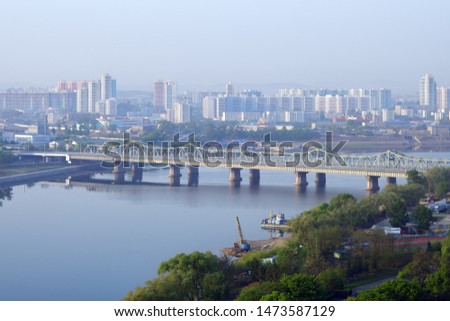Pyongyang, DPR Korea, North Korea. Bridge across  the Taedong River from the Yanggakdo island and skyline shown at dawn Royalty-Free Stock Photo #1473587129