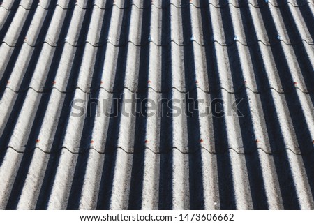 The beautiful background of the gray roof tiles that are shining in the morning shines with the lines and shadows and dimensions.